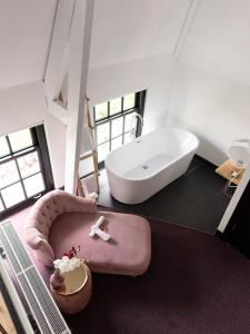 a bath room with a tub and a chair at Wolf Hotel Kitchen & Bar in Alkmaar