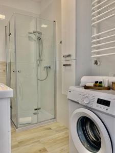 a washing machine in a bathroom with a shower at REMAR - Apartments Lake Biale in Augustów