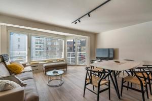 un salon avec un canapé et une table dans l'établissement Rustig, comfortabel app op 50meter van het strand, à Coxyde