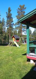 einen Park mit Spielplatz mit Rutsche in der Unterkunft Ekesberget Stugby Pippi Stuga in Ekshärad