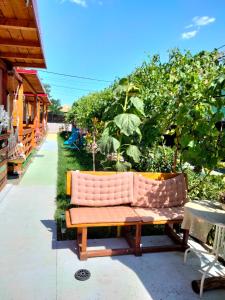 a pink couch sitting on a patio next to some trees at Casuta De La Mare Corbu in Corbu