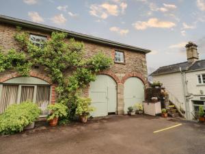 a brick house with two garage doors and plants at The Carriage in Lydney