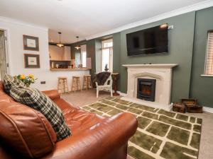 a living room with a couch and a fireplace at The Carriage in Lydney