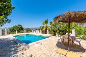 - une piscine avec des chaises et un parasol dans l'établissement Country villa in peaceful location, à Cútar