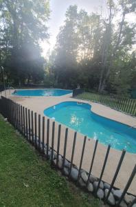 a swimming pool with blue water and a fence at Hemoso y Céntrico Departamento in Pucón