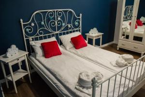 een slaapkamer met een wit bed met rode kussens bij Apartament Staromiejski Zakątek in Toruń