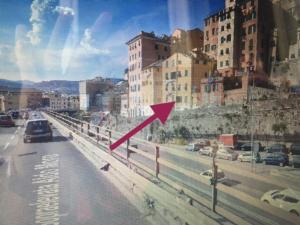 a red arrow on a city street with buildings at Ancient walls home in Genoa