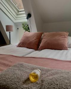 a bed with two pillows and a bottle on it at Lilla Brunn in Stockholm