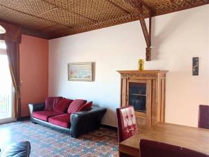 a living room with a red couch and a table at Villa du Port in Port-Vendres