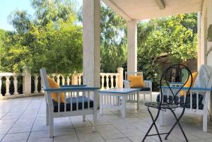 a patio with chairs and tables on a porch at Villa du Port in Port-Vendres