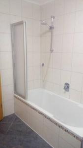 a bathroom with a shower and a white tub at Ferienwohnung DaWie in Öhringen