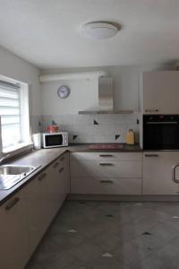 a white kitchen with a sink and a microwave at Ferienwohnung DaWie in Öhringen