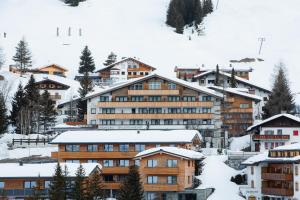 ein Hotel in einem Skigebiet im Schnee in der Unterkunft Hotel Plattenhof in Lech am Arlberg