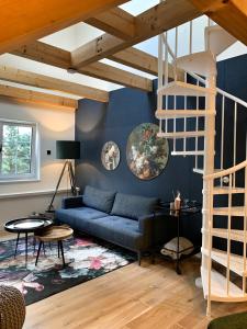 a living room with a blue couch and stairs at NJOLA in Sohland am Rotstein