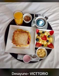 een bord ontbijtproducten met een broodje en fruit bij Victtorios Hotel in Satipo