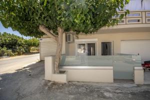a building with a tree in front of a house at Anna's Home in Kissamos