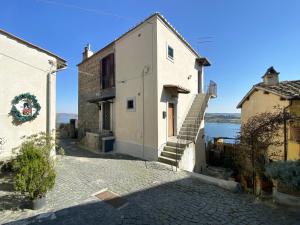 a building with stairs next to a body of water at Alloggio ad uso turistico - The Apartment n.2 in Anguillara Sabazia