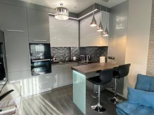 a kitchen with a counter and a blue chair at Noir Silvery Apartman in Szeged