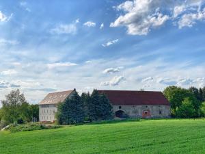 a large building in a field with a green field at NJOLA - Dein ruhiges Zuhause am Naturschutzgebiet in Sohland am Rotstein