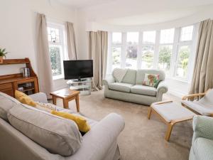 a living room with two couches and a tv at Seawinds 2a in Colwyn Bay