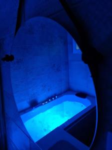 bañera con luz azul en el baño en Hostal Restaurante La Mancha, en Ruidera