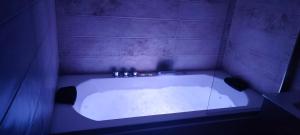 a bath tub in a bathroom with a purple wall at Hostal Restaurante La Mancha in Ruidera