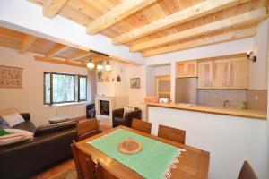Una sala de estar con una mesa y una cocina. en Forest house, en Cetinje