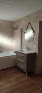 a bathroom with a sink and a tub and a mirror at Hostal Restaurante La Mancha in Ruidera