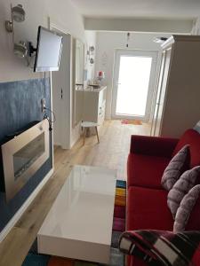 - un salon avec un canapé rouge et une table basse blanche dans l'établissement Strandgut, à Sellin