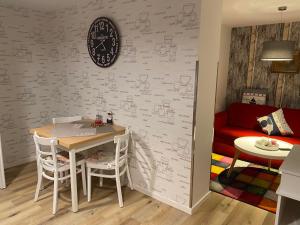 une salle à manger avec une table et une horloge murale dans l'établissement Strandgut, à Sellin 3 autres photos