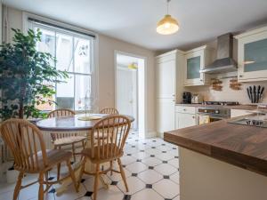 a kitchen with a table and chairs and a kitchen with a window at Pass the Keys Charming 2 bed cottage with parking in Canterbury in Canterbury
