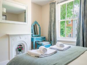 a bedroom with a bed and a mirror and a fireplace at Pass the Keys Charming 2 bed cottage with parking in Canterbury in Canterbury