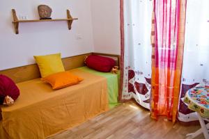 a room with a bed with colorful pillows and a table at Laxmi Guesthouse B&B in Genoa