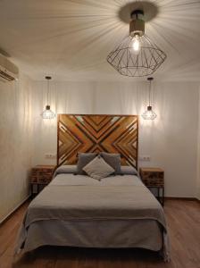 a bedroom with a large bed and two lights at Hostal Restaurante La Mancha in Ruidera