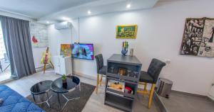 a living room with a table and chairs and a stove at Studio Gallery in Mostar