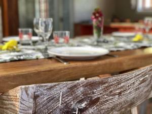 a wooden table with a plate and glasses on it at Ambiance Villa in La Digue