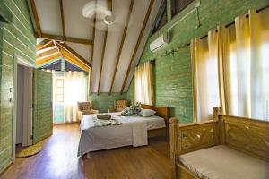 een slaapkamer met 2 bedden in een kamer met groene muren bij Ambiance Villa in La Digue