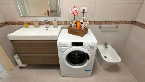 Un baño con lavadora y lavabo. en Rocas del Mar 129, en Costa del Silencio
