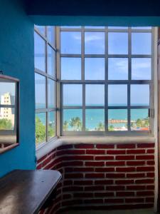 Cette chambre est dotée d'un mur en briques et de fenêtres donnant sur l'océan. dans l'établissement Hotel Villa Luz, à Puerto Escondido