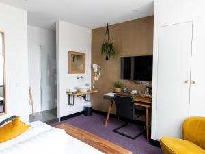 a bedroom with a desk and a computer in a room at Wolf Hotel Kitchen & Bar in Alkmaar