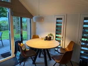 a dining room with a wooden table and chairs at Ferienhaus tinydroom im Europarcs Bad Hoophuizen am Veluwemeer in Hulshorst