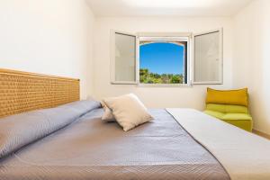 a bedroom with a large bed and a yellow chair at Villa Lodrea by Perle di Puglia in Morciano di Leuca