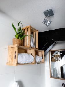 a wooden shelf with towels and a plant on a wall at Wolf Hotel Kitchen & Bar in Alkmaar +68 photos