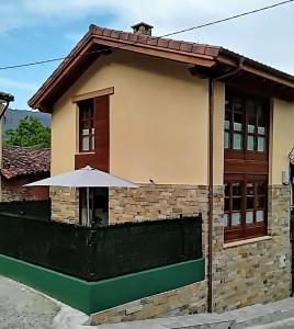 a small house with an umbrella in front of it at Casa gueli in Cangas de Onís