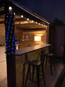 una cucina con bar con sedie e luci di Jolie Villa climatisée piscine chauffée Perpignan a Perpignano
