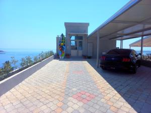 a car parked in front of a house with a surfboard at Flabelline Apartments in Bar