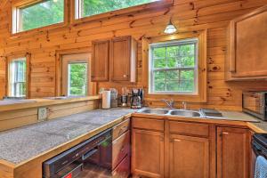 eine Küche mit Holzschränken und einem Waschbecken in der Unterkunft Cozy Boone Cabin with Deck Close to Downtown! in Boone