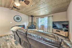 un divano in pelle in soggiorno con orologio di Sleepy Bear Cabin in Ruidoso Deck and Yard Games! a Ruidoso