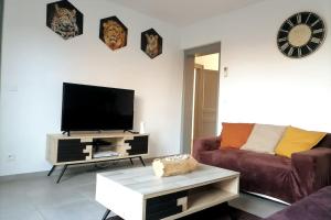 een woonkamer met een bank en een flatscreen-tv bij GAYANTINE - Spacieuse Confortable Proche Gayant Expo FIBRE in Roost-Warendin
