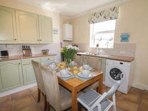 a kitchen with a table and chairs and a washing machine at Coastal Corner in Whitby